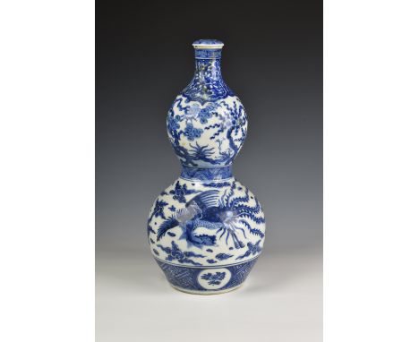 A Chinese porcelain blue and white double gourd vase and cover probably 18th / early 19th century, potted with two distinct b