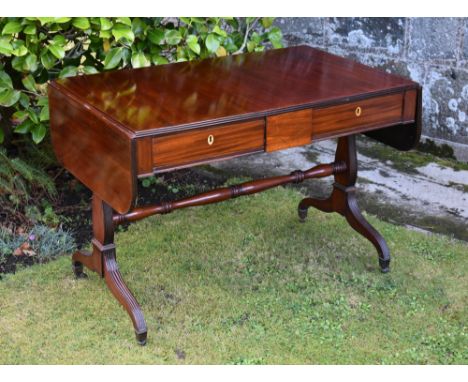 A late Regency mahogany sofa table the rounded rectangular dropflap top with reeded edge, over a diamond strung tablet frieze