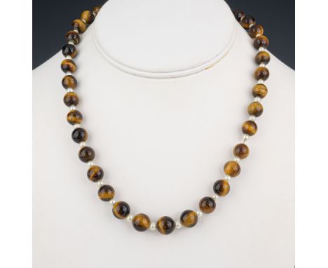 A tiger's eye and seed pearl necklace with silver and seed pearl clasp, 17in. (43.2cm.) long; together with a baroque pearl b