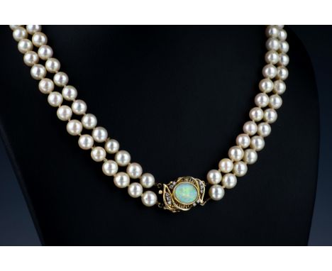 A two strand cultured pearl necklace with 14ct gold, opal and diamond clasp with 7mm. pearls, the clasp with oval opal and te