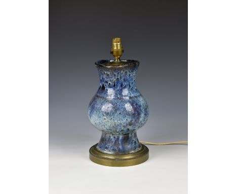 A Chinese porcelain flambe glazed lamp, the stoutly potted vase with a thick, streaked and mottled blue glaze with white pool