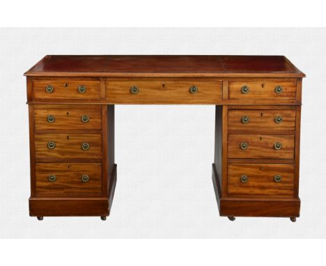 An Edwardian mahogany double pedestal desk the caddy moulded top with inset gilt tooled red leather, over three frieze drawer