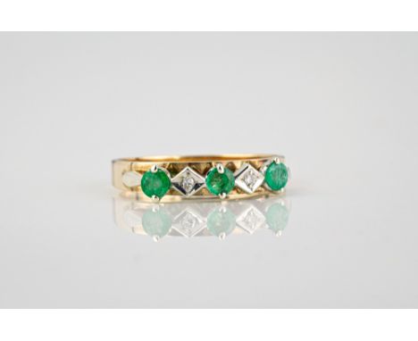 A 9ct gold, emerald and diamond ring with three round cut emeralds divided by two eight cut diamonds, size I.  