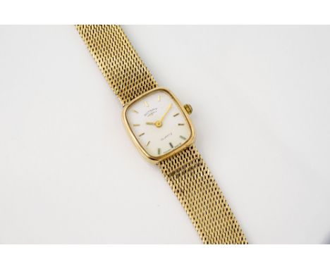 A ladies 9ct gold Rotary quartz wrist watch the white, rounded rectangular dial with applied gilt batons, with integral 9ct g