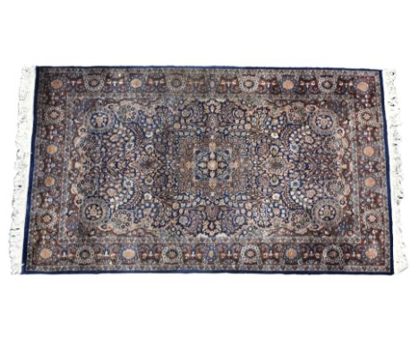 A Persian Isfahan style rug the central pendant medallion on a dark blue ground with all over decoration of scrolling, flower