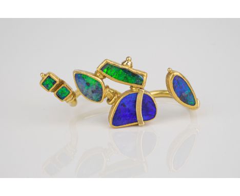 An unusual handmade 18ct yellow gold and black opal double shank ring the two open shanks with various abstractly shaped opal