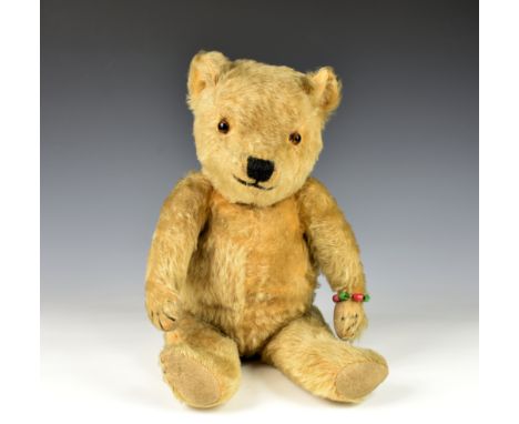 A Golden mohair teddy bear c. 1930's, possibly Chiltern, orange glass eyes, four stitched claws, beige felt pads, 17in. tall.