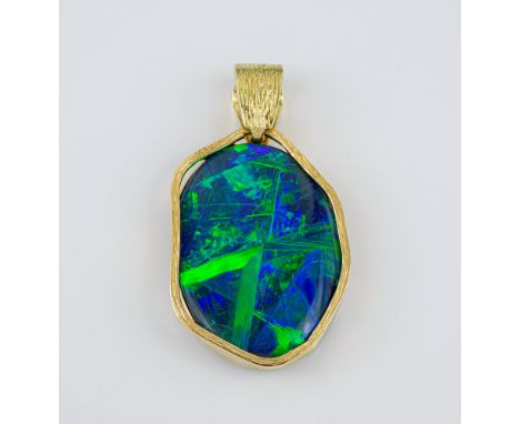 A fine 18ct gold and black opal pendant the oval 29 x 21mm. opal of fine colour and iridescence, approx. 9ct, within a shaped