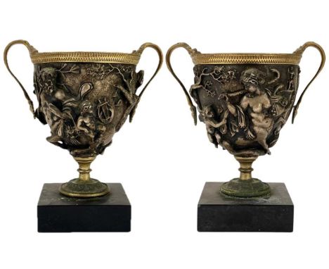 A pair of grand tour gilt bronze and silvered urns or vases. 19th century, with double serpent handles, cast in deep relief w