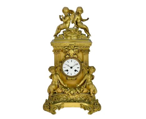 An ornate French ormolu mantel clock. Circa 1860, the Baroque case mounted and flanked with winged cherubs, with a scroll and
