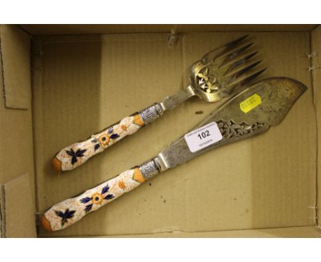 A silver plated fish knife and fork with Imari patterned handles and silver collars