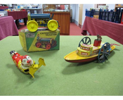 Three Mid XX Century Tinplate Toys, a Caterpillar Tractor by Mettoy, boxed, tinplate clockwork Paddle Steamer and a tinplate 