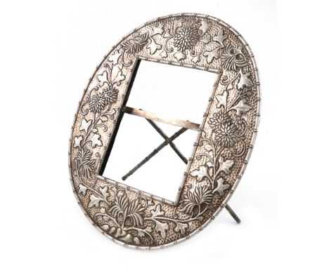 A Chinese silver photograph frame, marked with Chinese characters, oval form, embossed with flowers and foliate decoration on