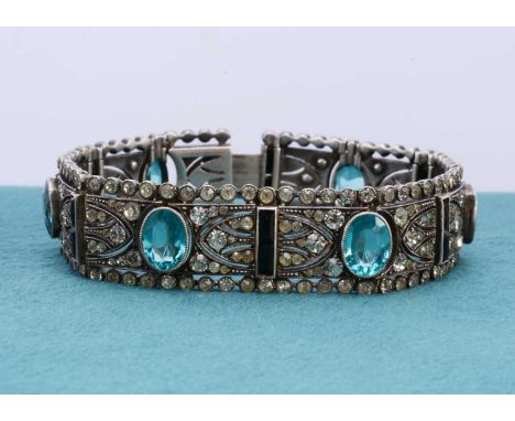 An art deco silver and paste bracelet, the architectural rectangular hinged panels centred with light blue oval cut gems surr