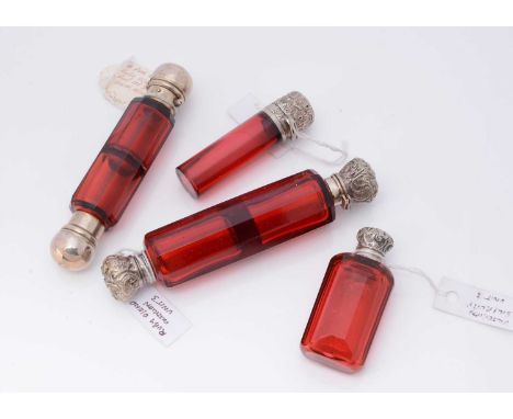 Four Victorian red cut glass scent bottles, two double ended examples, a cylindrical bottle and a rectangular step cut scent 