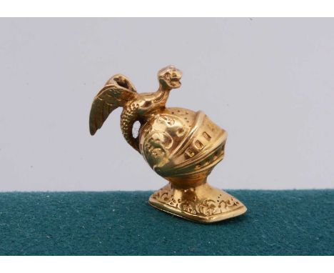 A 19th century miniature gold snuff charm, modelled as a knight's helmet with winged dragon, the base with hinged section wit