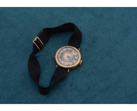 A lady's 18ct gold trench watch, with manual jewelled movement, silver face with Arabic numerals, glass af, 2.4cm lug to lug,