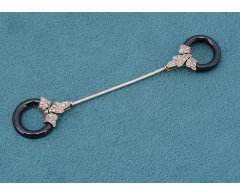 An art deco diamond and onyx platinum set jabot pin, the onyx pierced roundels with diamond encrusted stylised fleur de lys, 