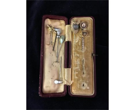 A small box containing stick pins, one 18ct, one 9ct.
