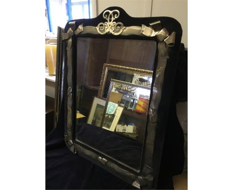 A large antique mirror with decorative silver surround 