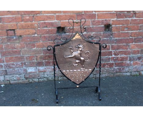 A SHIELD SHAPED COPPER AND BENT IRON WORK FIRESCREEN,  with rampant lion decoration, H 84.5 cm