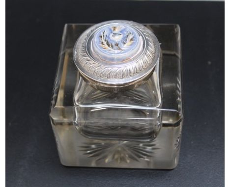 A HALLMARKED SILVER LIDDED GLASS INKWELL BY THE DOUGLAS CLOCK COMPANY - BIRMINGHAM 1902, the lid inset with a thistle emblem,