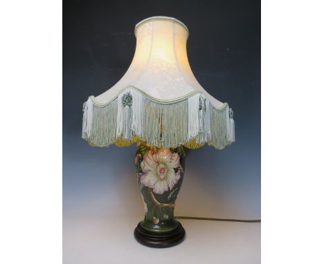 A LARGE MOORCROFT FLORAL PATTERN TABLE LAMP, dark green ground to lamp base, with shade, H 30 cm (excluding shade)