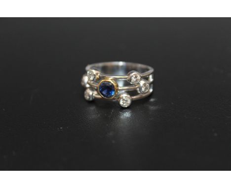 A HANDMADE 18 CARAT WHITE GOLD SAPPHIRE AND DIAMOND SPLIT BAND RING, set with a single sapphire of an estimated 0.58 carat se