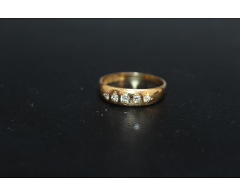 A HALLMARKED 18 CARAT GOLD DIAMOND SET BAND, having 5 diamonds totaling an estimated 0.12 carat, approx weight 3g, ring size 