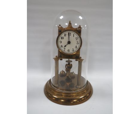 AN EARLY 20TH CENTURY BRASS CASED TORSION CLOCK, with three ball carriage under plastic dome, H 30 cm