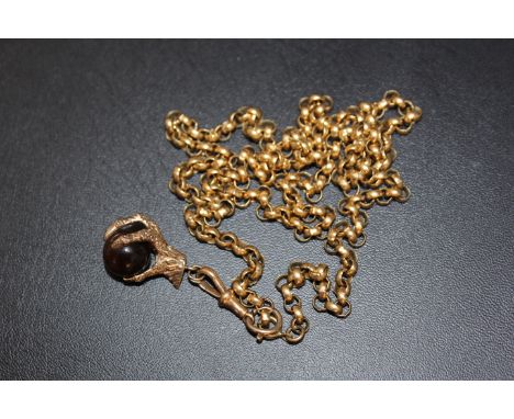 A HALLMARKED 9 CARAT GOLD CLAW HOLDING A TIGERS EYE BALL, on a link stamped 18 on an unmarked yellow metal roller chain, appr