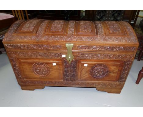 An Indian carved teak domed top trunk with brass clasp, 30"