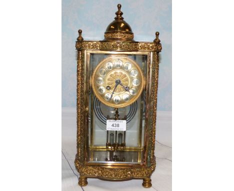 An ornate gilt metal 4 glass clock with domed top, relief decorated columns, and French drum striking movement with mercury c
