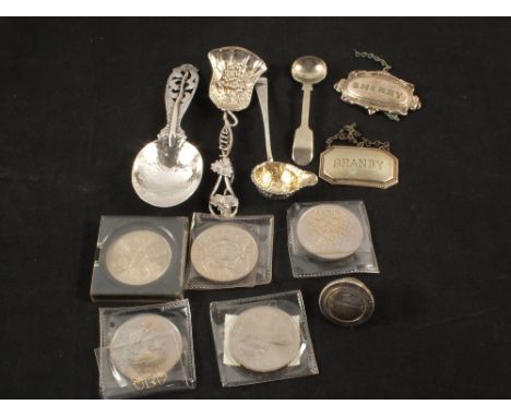A hammered spoon with thistle decoration, a vine leaf caddy spoon, decorative sauce ladle (all unmarked) plus coins and Silve