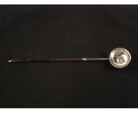 An unmarked toddy ladle with horn twist handle set with 1709 Queen Anne shilling