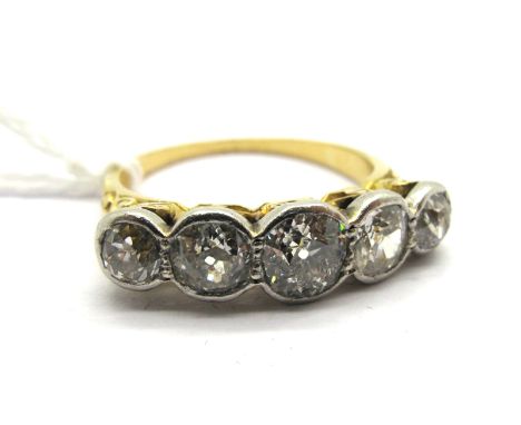 A Large Five Stone Diamond Ring, the graduated old cut stones collet rubover set, within scroll carved setting (worn). 