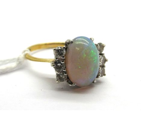 An 18ct Gold Opal and Diamond Ring, the central oval cabochon opal four claw set between six brilliant cut diamonds.