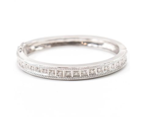 A white gold and diamond set bangle bracelet. The bracelet being set with 21 round cut diamonds between rope twist borders, t
