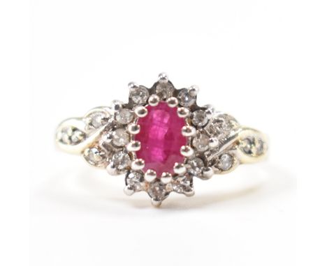 A hallmarked 9ct gold, ruby &amp; diamond halo ring. The ring having an oval cut prong set ruby surrounded by a halo of round