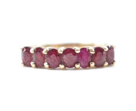 A hallmarked 9ct gold &amp; ruby ring. The ring having seven faceted oval cut prong basket set rubies on a tapered shank. Hal