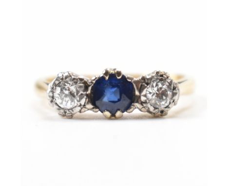 A vintage 18ct gold, diamond &amp; sapphire three stone ring. The ring having a central round cut claw set sapphire flanked b