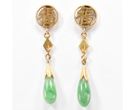 A pair of gold and jade drop earrings. The earring having round stud with pierced detailing featuring Chinese character marks