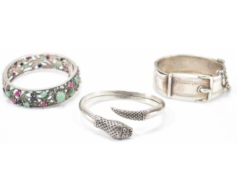 A group of three silver bangle bracelets. The lot to include a Victorian silver belt bracelet (unmarked, tests indicate silve