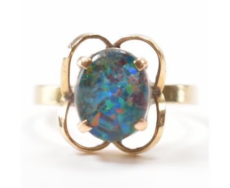 A vintage gold and opal doublet dress ring. The ring having an opal doublet set to the centre with a quatrefoil mount on a pl