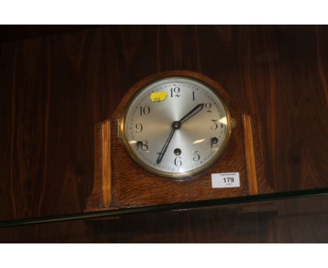 AN OAK MANTEL CLOCK