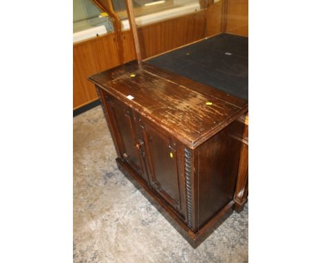 AN OAK JACOBEAN STYLE TWO DOOR CUPBOARD WITH A TROLLEY (2)