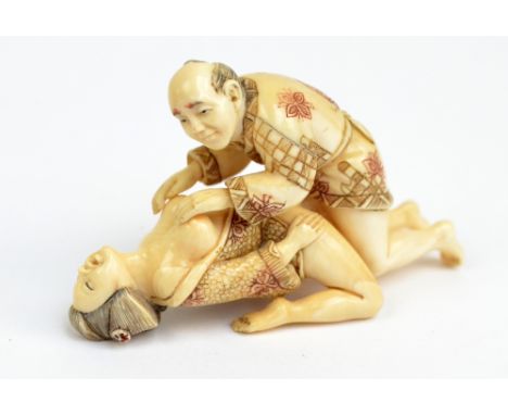 A Japanese Meiji period carved ivory erotic two section figured okimono of copulating couple, with incised and inked detail r