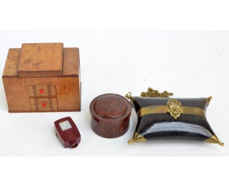 An early 20th century bird's eye maple cigarette dispenser, 14.5 x 9cm, a bakelite cylindrical box and cover, a horn brass mo