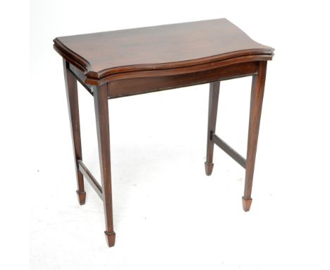 An early 20th century mahogany serpentine outline foldover card table.