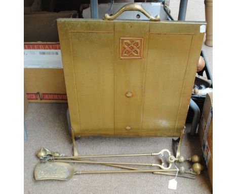 An Art Deco style brass fire screen with single Celtic motif with handle, raised on legs and a three piece brass companion se
